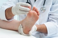 Huisarts onderzoekt een patiënt met een branderige voet / Bron: Alexander Raths/Shutterstock.com