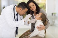 Huisarts onderzoekt kind met keelpijn / Bron: Istock.com/michaeljung