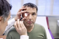 Arts onderzoekt man die last heeft van wazig zien / Bron: Image Point Fr/Shutterstock.com