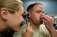 Een man voert de Valsalva-manoeuvre uit terwijl zijn oor met een otoscoop wordt onderzocht / Bron: U.S. Air Force photo by Airman 1st Class Kate Thornton, Wikimedia Commons (Publiek domein)