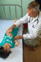 Palpatie: een arts bevoelt de buik van een kind / Bron: JoAnn Moravac, U.S. Army, Wikimedia Commons (Publiek domein)